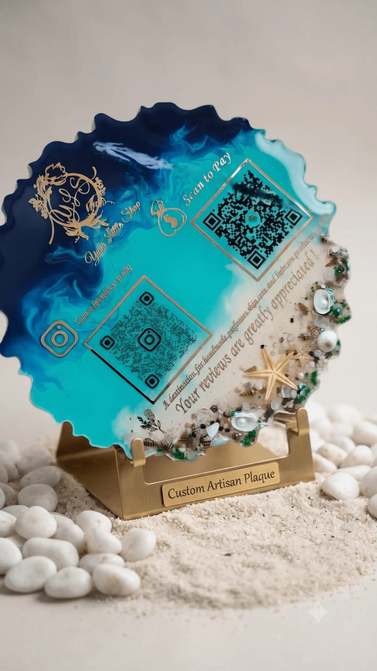Custom resin QR code plaque with blue, teal, and white swirls, decorated with seashells and starfish, on a gold stand.
