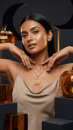 Woman in a champagne slip dress wearing a gold crescent moon pendant with dried flowers, surrounded by amber decor.