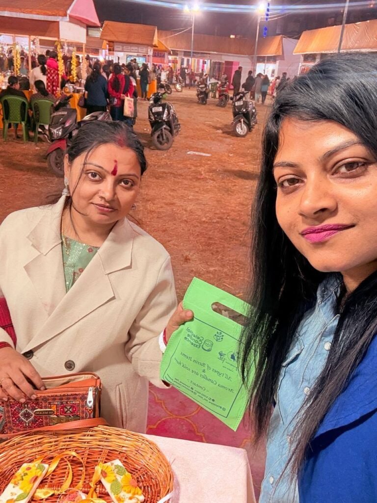Two women at an outdoor market stall at night, one holding a green bag, with a basket of items on the table.
