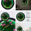 Round resin art with a boat, pink lotus flowers, and lily pads on green water, framed in black, with green LED backlight.