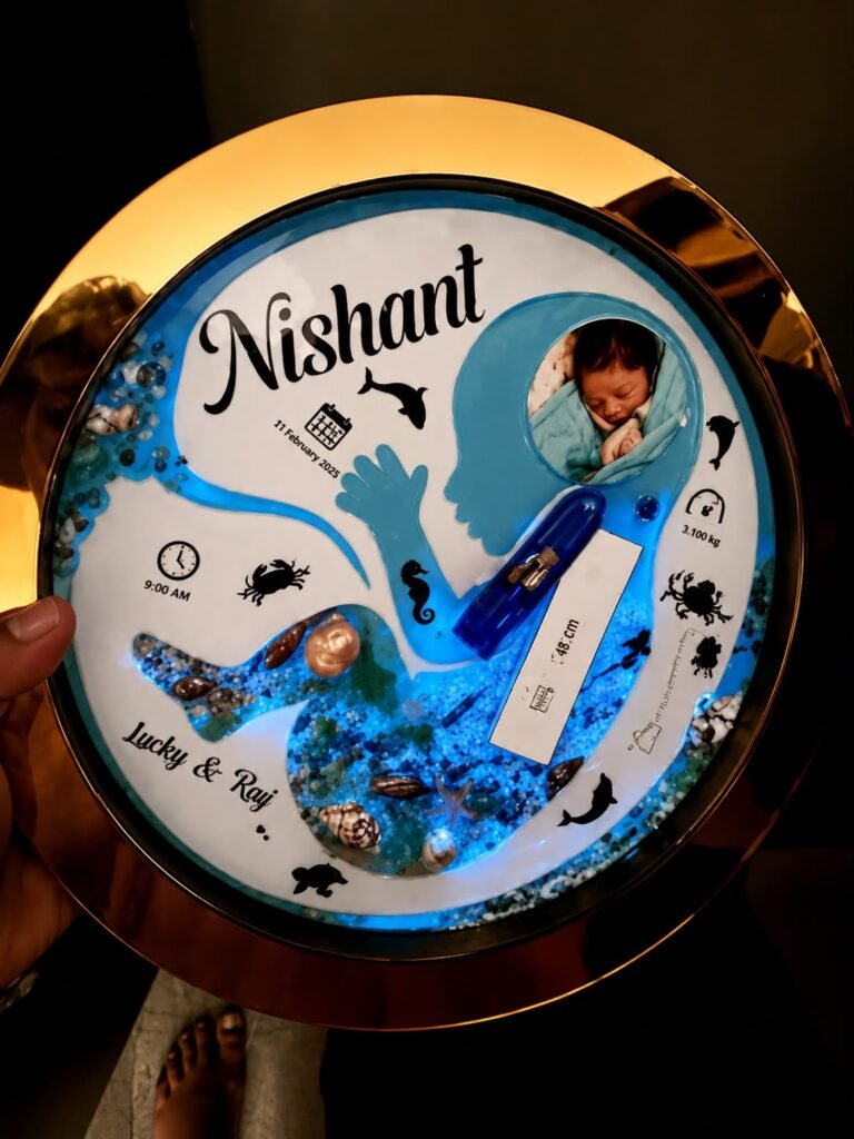 Handheld personalized resin birth keepsake for Nishant, with baby's photo, birth stats, and a glowing blue underwater design.