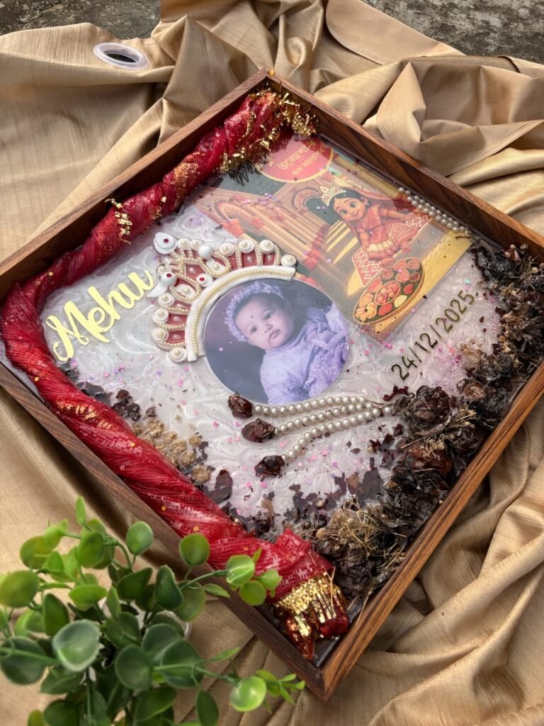 Personalized wooden-framed resin keepsake tray with baby photo, gold 'Mehu' name, date, red fabric, pearls, and dried botanic