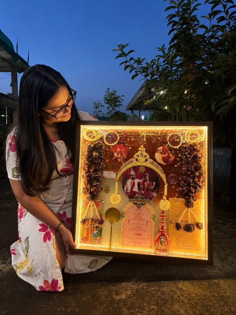 Woman holding a glowing custom resin keepsake frame with a wedding photo, invitation, and dried flowers.