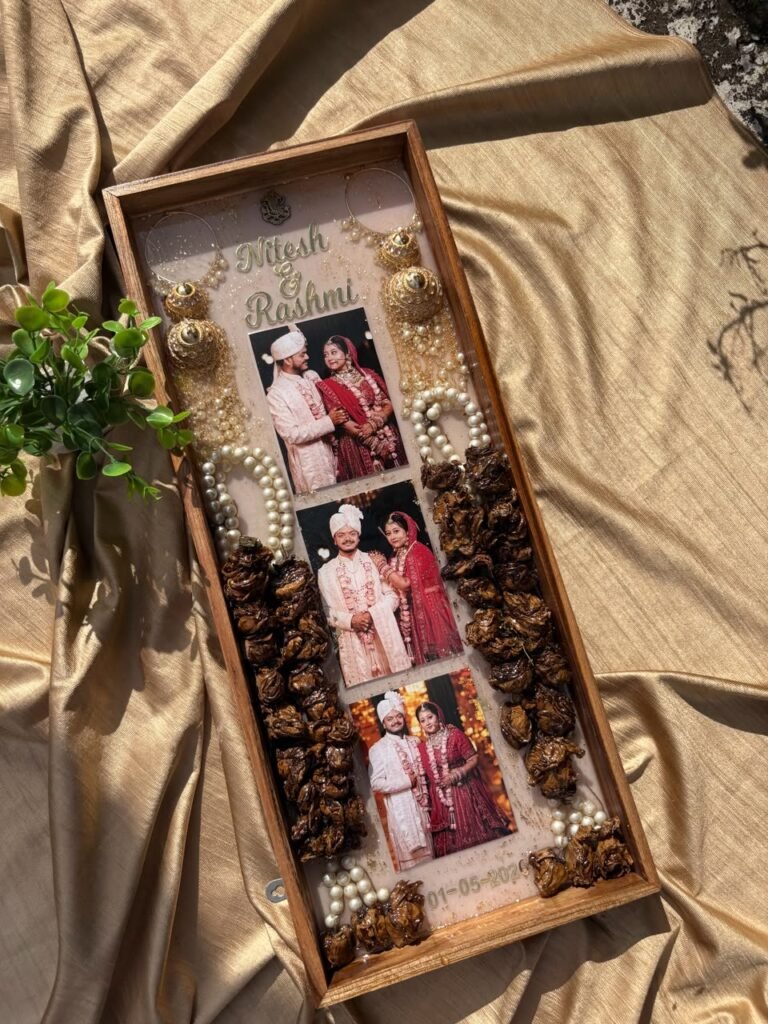 Wooden resin keepsake tray with three wedding photos, names Nitesh & Rashmi, pearls, golden jhumkas, and dried roses on golde
