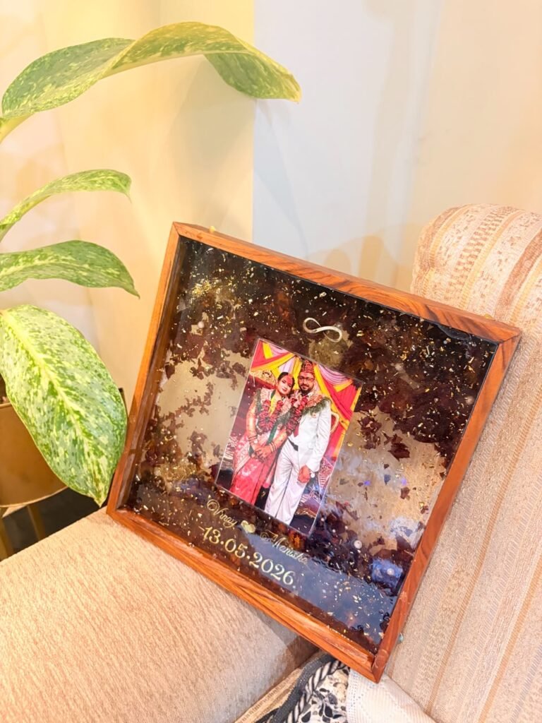 Personalized wooden resin frame with a wedding photo, gold flakes, dried petals, and engraved names/date.