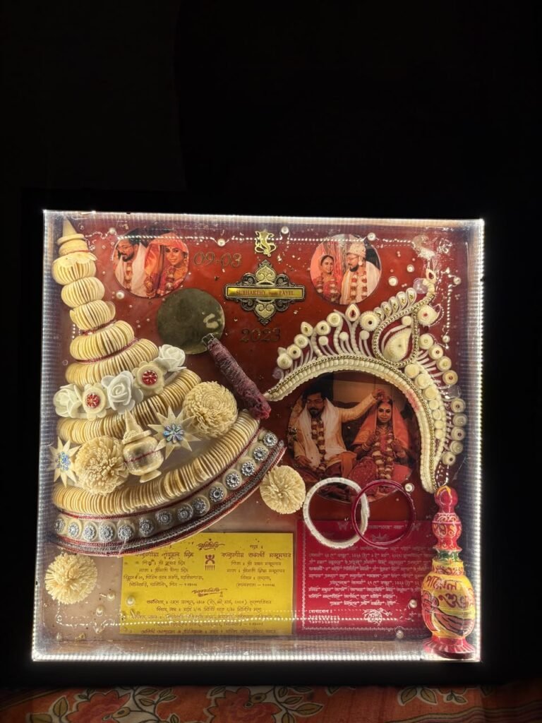 A custom resin wedding keepsake box featuring photos of a couple, traditional Bengali wedding headwear, and a red background.